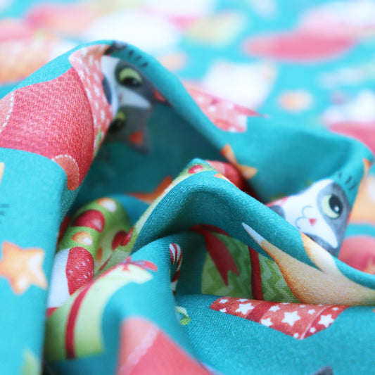 Tessuto in Raso di 100% Cotone: Gatti di Natale su sfondo Verde