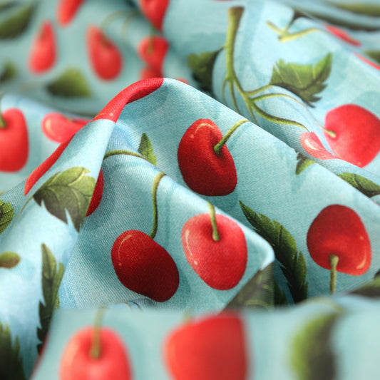Tessuto in Raso di 100% Cotone: Cherry Crush - Ciliegie su sfondo Celeste